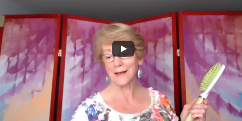 Elise Kerns hold a hair brush video screen shot for video about relieving shoulder, neck and back pain
